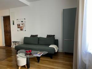 salon z zieloną kanapą i stołem w obiekcie Cosy Appartement Lyon Valmy - parking w mieście Lyon