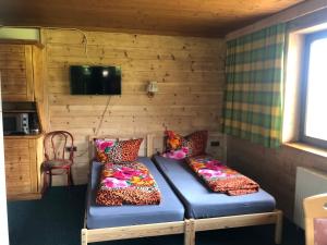 a room with two beds in a wooden room at Appartement Grünfelder in Oberperfuss