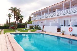 a swimming pool in front of a house at Apartamentos Las Pérgolas in Son Parc