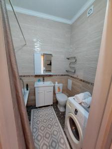 a bathroom with a washing machine and a washer at Expo new life in Taldykolʼ