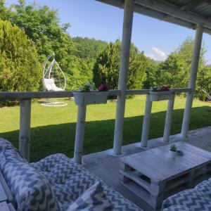una veranda con letto, tavolo e sedia di Vila Obradovic ad Arilje