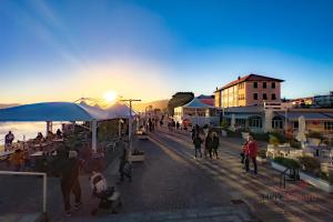a group of people walking down a street at sunset at Sea 3 min - Trains 8 - min - Free WiFi - AC in Albisola Superiore