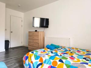 una camera con letto e TV a parete di Spacious Double Bedroom with Private Toilet and Shared Kitchen with on premesis parking a Oldbury