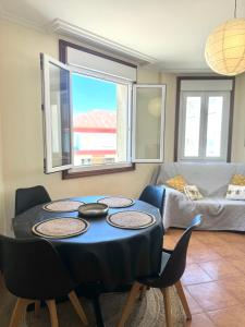 Una sala de estar con una mesa y sillas y un sofá. en Mar A Villa, en A Illa de Arousa