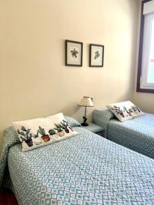 1 dormitorio con 2 camas con plantas. en Mar A Villa, en A Illa de Arousa