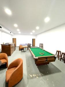 Cette chambre comprend un billard et des chaises. dans l'établissement Hostel Casa Mia SR, à Saranda