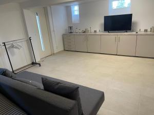 uma sala de estar com um sofá e uma televisão de ecrã plano em New flat in Limhamn em Limhamn