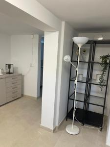 um quarto com um candeeiro branco e uma prateleira em New flat in Limhamn em Limhamn