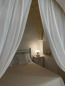 a bedroom with a bed with a white canopy at Masseria Don Sante in Fasano