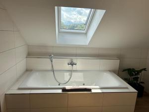 a bathroom with a bath tub with a window at Gasthof Steinbichler in Nussdorf am Attersee