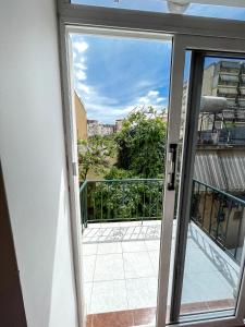 una puerta corredera de cristal con vistas a un balcón en Hostel Casa Mia SR en Sarandë