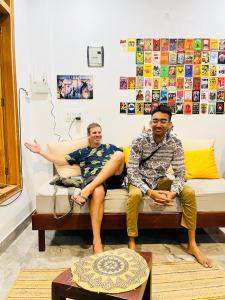 two men and a woman sitting on a couch at wuiD stayin wakeupinDoon in Dehradun