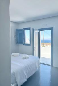 - une chambre blanche avec un lit et 2 serviettes dans l'établissement Oinos Luxury Suites, à Foinikiá