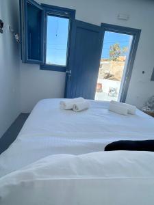 - une chambre avec un grand lit blanc et 2 serviettes dans l'établissement Oinos Luxury Suites, à Foinikiá