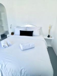 - un lit blanc avec 2 serviettes blanches dans l'établissement Oinos Luxury Suites, à Foinikiá