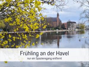 einen Fluss mit einem Gebäude und einem Baum mit gelben Blättern in der Unterkunft Schöne, ruhige Stadtwohnung, Küche, SmartTV, 1-5 Pers in Brandenburg an der Havel