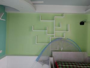 um quarto com uma parede verde e uma escada em Rupjan Vila em Muktāgācha