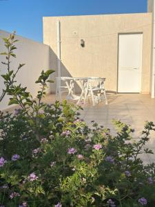 a picnic table on the patio of a building with flowers at Villa Shams - with Pool in Mellita