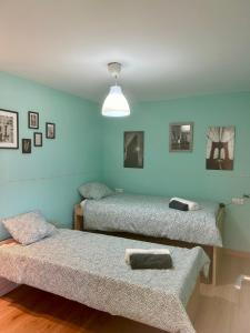 Duas camas num quarto com paredes azuis em El Txoko Andaluz em Cantillana