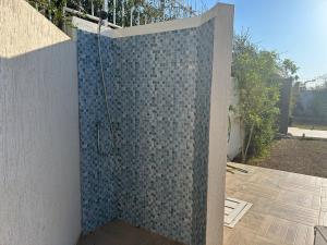 a bathroom with a shower with a tile wall at Villa Shams - with Pool in Mellita