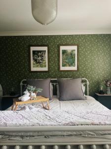 a bedroom with a bed and a table at The Romantic Pink English Cottage at Tamborine Mountain in Mount Tamborine +49 photos