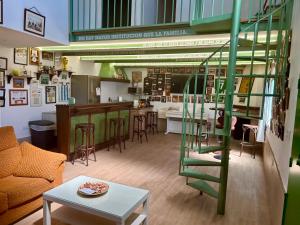 a living room with a spiral staircase and a kitchen at El Txoko Andaluz in Cantillana