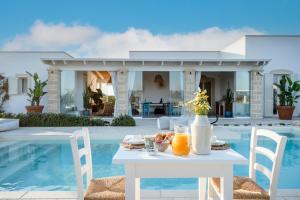 a table with fruit on it next to a swimming pool at Villa Lucia - Exclusive Private Pool in Gallipoli