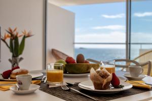 un tavolo con piatti di cibo e bicchieri di succo d'arancia di Sud Ibiza Suites a Ibiza Città