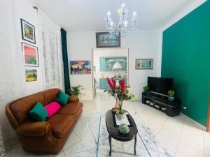 a living room with a brown couch and a tv at JCK Tuscany Apartment in Livorno