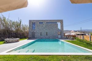 uma villa com piscina em frente a uma casa em Achatis Apartments with sea view em Kolymvari