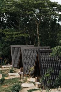 une maison avec un toit noir dans un jardin dans l'établissement Seattle Knuckles, à Rangala