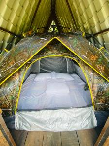 a tent with a bed in it at Seattle Knuckles in Rangala