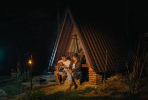 un groupe de personnes assises à l'extérieur d'une cabine la nuit dans l'établissement Seattle Knuckles, à Rangala