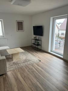 ein leeres Wohnzimmer mit einem Tisch und einem TV in der Unterkunft Gemütlich wohnen in Sinsheim in Sinsheim