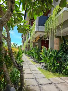 a walkway in front of a building with plants at Wasabi in Canggu