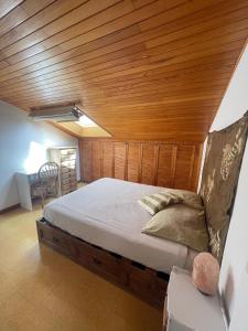 a bed in a room with a wooden ceiling at Ganbara in Hondarribia +21 photos