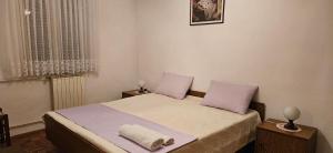um pequeno quarto com uma cama com almofadas roxas em Apartment LAGUNA 22 em Izola