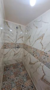 baño con ducha y suelo de baldosa. en Gite taouraout, en Midelt