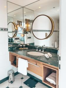 a bathroom with a sink and a large mirror at Hilton Imperial Dubrovnik in Dubrovnik