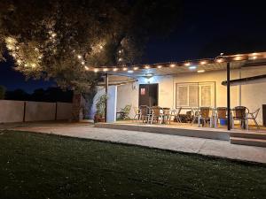 uma casa com um pátio com cadeiras e luzes em Casa Rural Quejigo con piscina em Santa Olalla del Cala