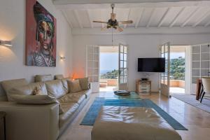 uma sala de estar com um sofá e uma ventoinha de tecto em Ferienhaus Équilibre em Saint-Peïre-sur-Mer