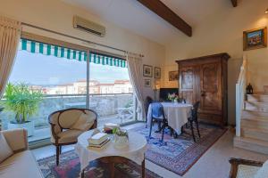 ein Wohnzimmer mit einem Tisch und einem großen Fenster in der Unterkunft Appartement Globetrotter in Saint-Raphaël