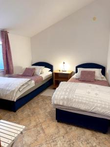 科尔丘拉格吉奇公寓酒店的一间卧室配有两张床和一张边桌 更多66张照片