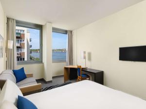 a hotel room with a bed and a tv at Novotel Budapest Danube in Budapest