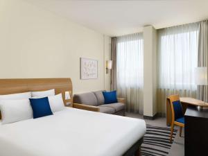 een hotelkamer met een groot bed en een bureau bij Novotel Budapest Danube in Boedapest