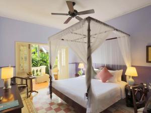 a bedroom with a bed with a ceiling fan at La Veranda Resort Phu Quoc - MGallery in Phu Quoc