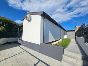 a white house with a fence and a sidewalk at Seaside Cottage Barbariga in Peroj
