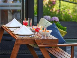 een houten tafel met borden met eten en drinken erop bij The Riverston Grand in Matale