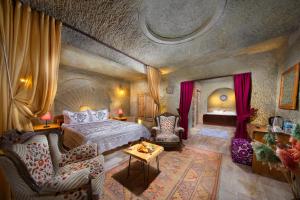 於爾居普的住宿－World Cave House，一间卧室配有一张床、一张沙发和一张桌子