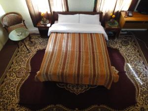 Una cama en una habitación de hotel con colcha. en Noorband Qalla Hotel,Bamyan, 